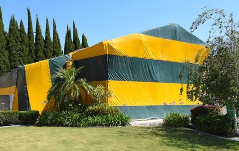 a house covered in a fumigation tent